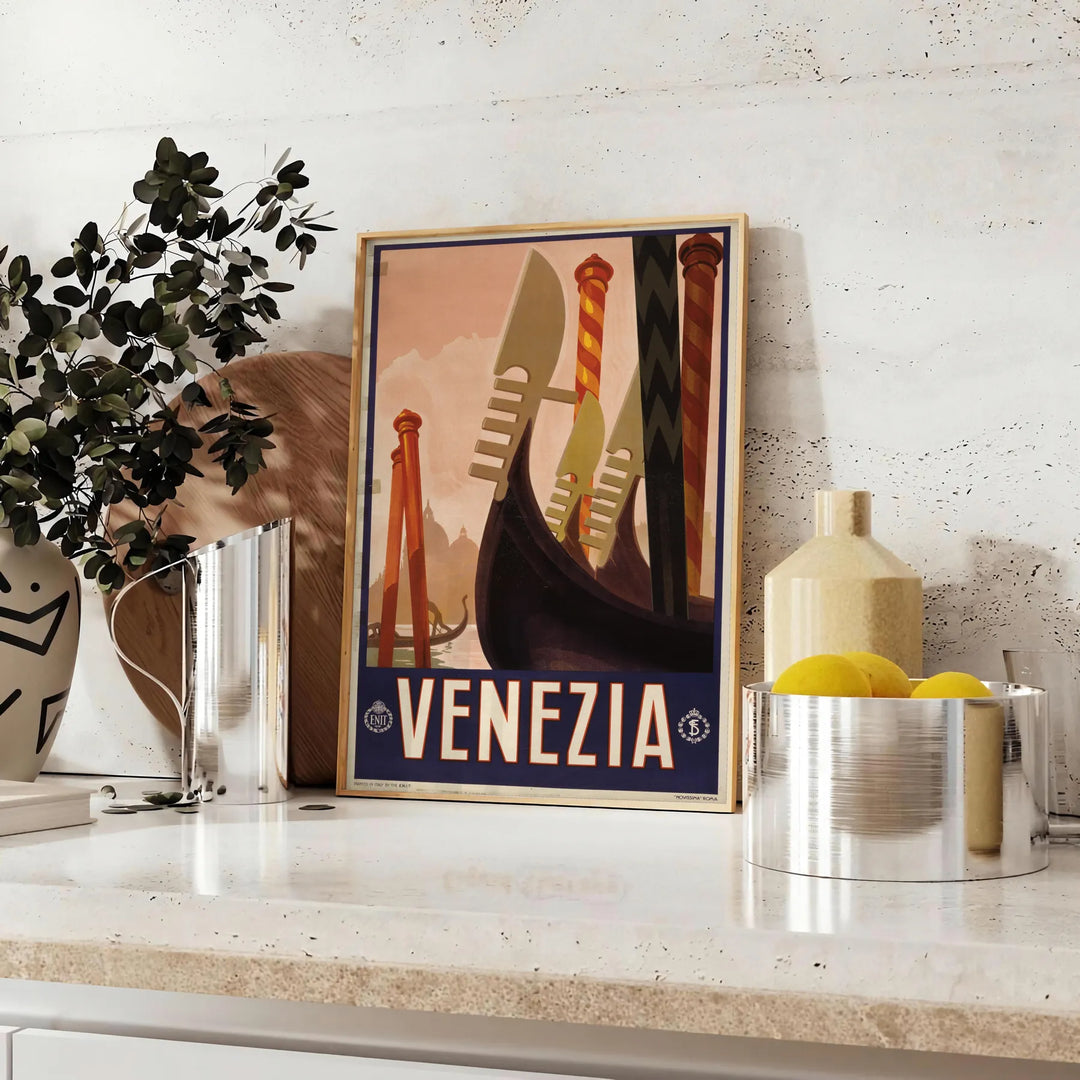 A vintage-style poster featuring iconic Venice canals and gondolas in green and black tones - styled on a counter with eucalyptus and a bowl of lemons