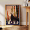 A vintage-style poster featuring iconic Venice canals and gondolas in green and black tones - beside a round wooden side table with books