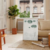A vintage Japanese print featuring traditional motifs in green and white tones - in a Parisian living room with a sofa and a fig plant