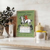 A vintage-style poster depicting rural life with muted gray and black tones - styled on a counter with eucalyptus and a bowl of lemons