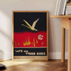 Vintage travel poster featuring bold black and orange colors - beside a round wooden side table with books