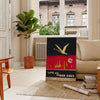 Vintage travel poster featuring bold black and orange colors - in a Parisian living room with a sofa and a fig plant