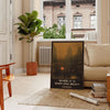 Vintage travel poster featuring a scenic landscape in rich browns and greens - in a Parisian living room with a sofa and a fig plant