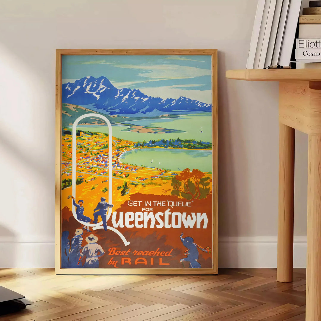 vintage poster of Queenstown featuring lush green landscapes and serene blue skies - beside a round wooden side table with books