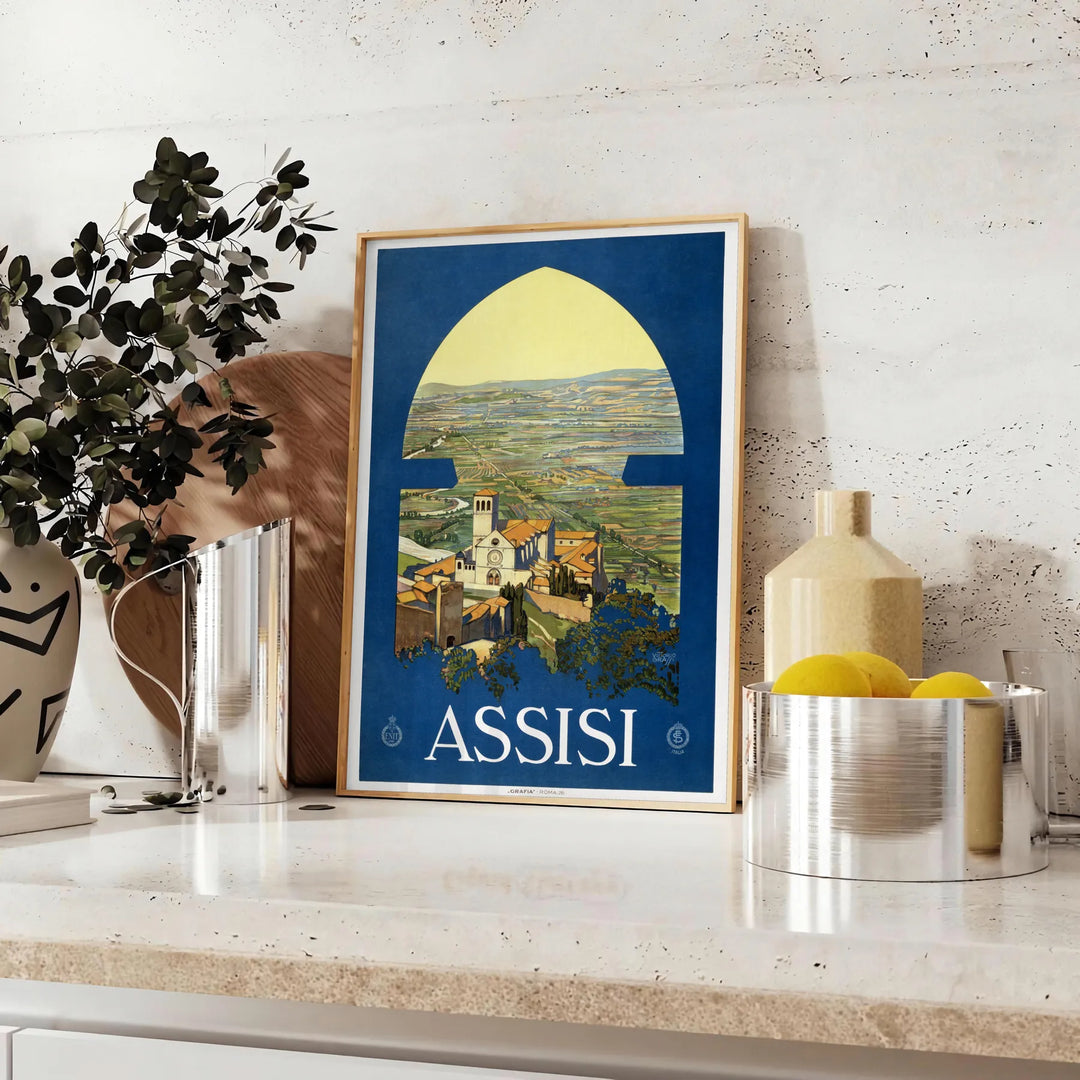 Affiche vintage d'Assise montrant la ville perchée en vert et bleu - sur un plan de travail avec eucalyptus et coupe de citrons