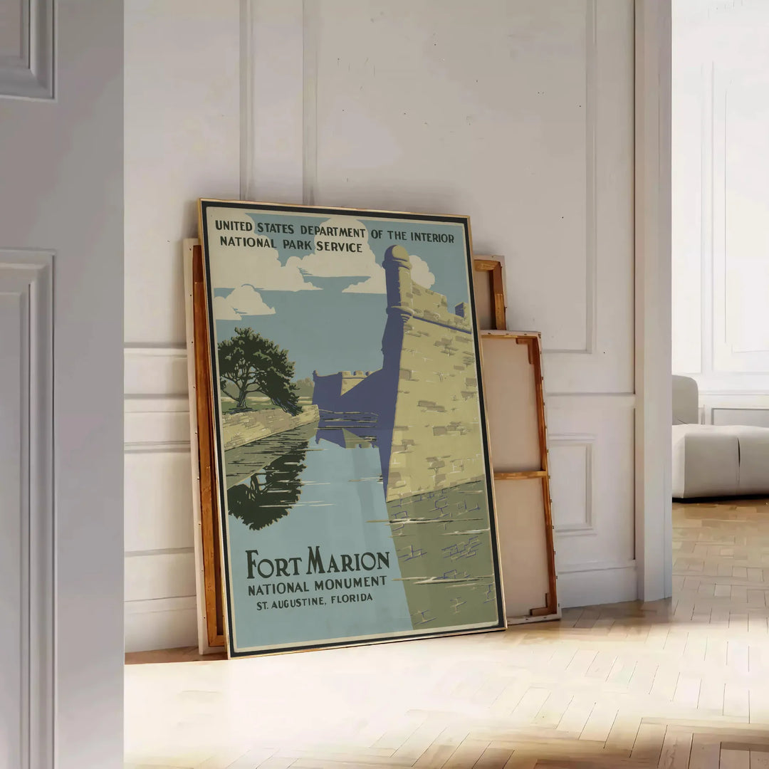 Affiche de voyage vintage de Fort Marion avec des tons verts et gris - posée sur un parquet à chevrons contre un mur à moulures