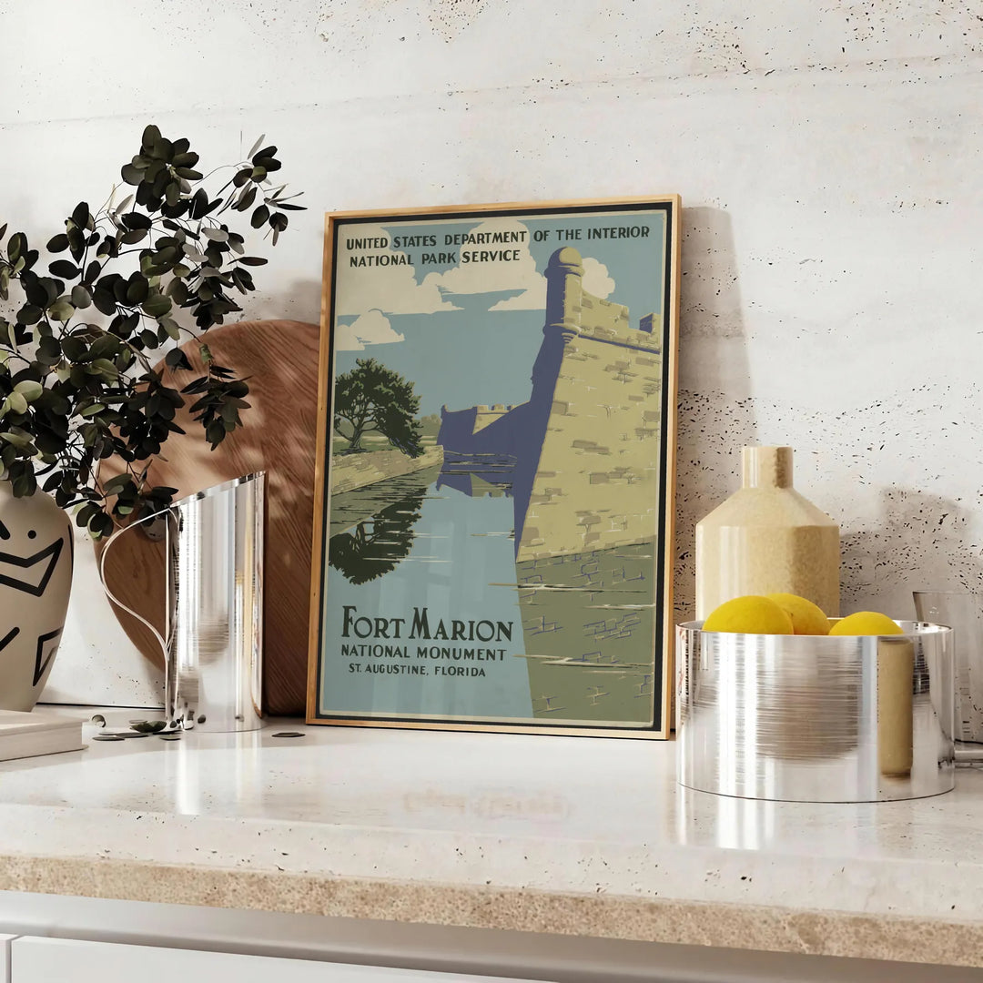 Affiche de voyage vintage de Fort Marion avec des tons verts et gris - sur un plan de travail avec eucalyptus et coupe de citrons