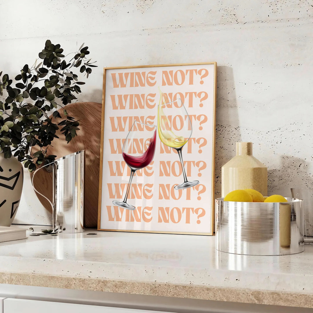 A playful kitchen poster featuring the phrase 'Wine Not' in bold letters, with yellow and purple colors. - styled on a counter with eucalyptus and a bowl of lemons