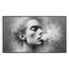A woman smoking in soft gray and green tones - in a black frame