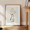Silhouette of a woman in bohemian style against gray and black background - beside a round wooden side table with books