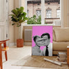 A pink and purple abstract artwork featuring a woman and a man - in a Parisian living room with a sofa and a fig plant