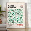 Abstract polka dot patterns in gray and blue by Yayoi Kusama - in a bright minimalist room with a plant and an armchair