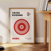Abstract pattern of black dots on an orange background by Yayoi Kusama - beside a round wooden side table with books