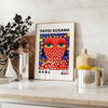 Motifs colorés de pois en orange et bleu par Yayoi Kusama - sur un plan de travail avec eucalyptus et coupe de citrons