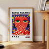 Motifs colorés de pois en orange et bleu par Yayoi Kusama - à côté d'une table d'appoint ronde en bois avec des livres