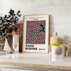 Abstract polka dot pattern in green and orange by Yayoi Kusama - styled on a counter with eucalyptus and a bowl of lemons