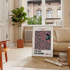 Abstract polka dot pattern in green and orange by Yayoi Kusama - in a Parisian living room with a sofa and a fig plant