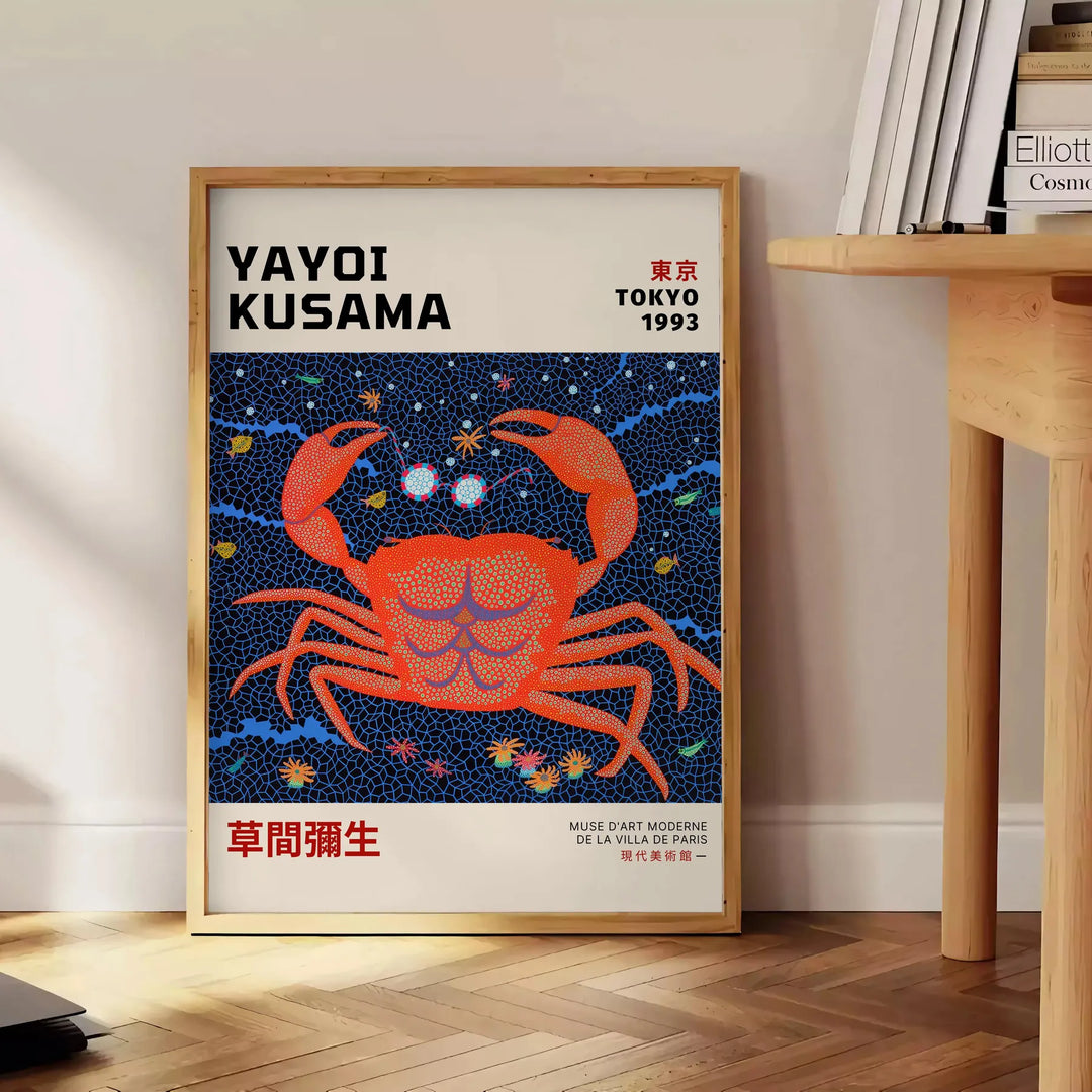 Abstract polka dot patterns in orange and blue by Yayoi Kusama - beside a round wooden side table with books