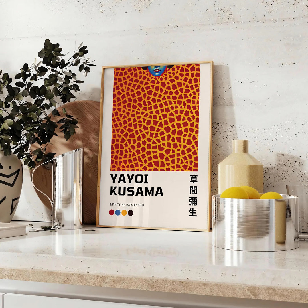 Abstract polka dot patterns in black and orange by Yayoi Kusama - styled on a counter with eucalyptus and a bowl of lemons