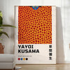 Abstract polka dot patterns in black and orange by Yayoi Kusama - in a bright minimalist room with a plant and an armchair