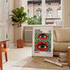 Abstract polka dots in orange and blue by Yayoi Kusama - in a Parisian living room with a sofa and a fig plant