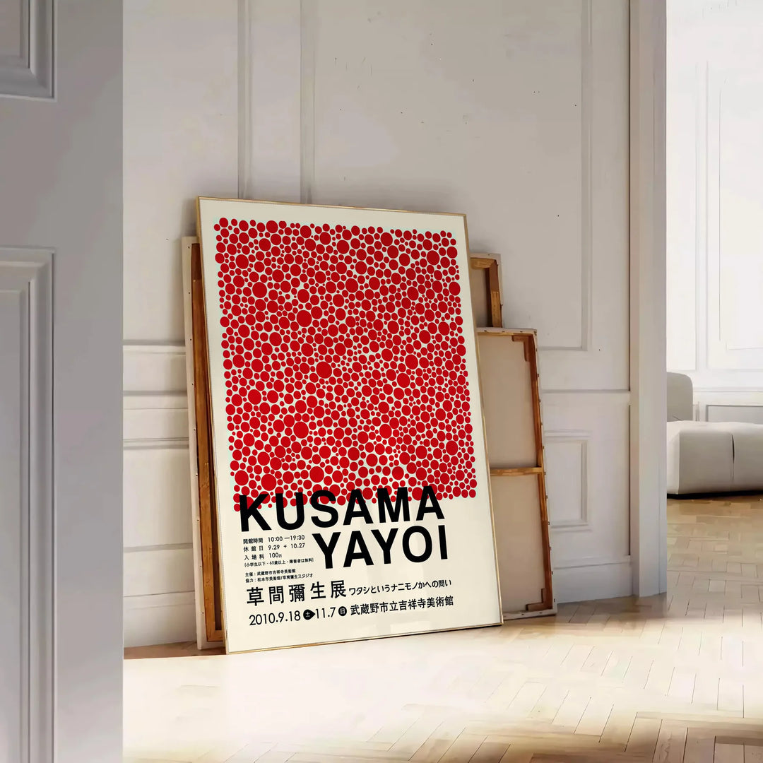 Red dots on a white background with black accents by Yayoi Kusama - leaning on a herringbone floor against a white panelled wall