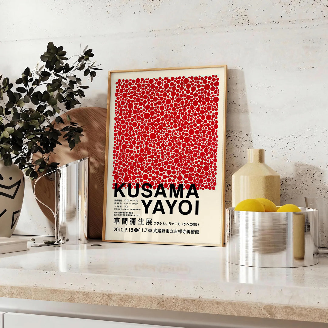 Red dots on a white background with black accents by Yayoi Kusama - styled on a counter with eucalyptus and a bowl of lemons