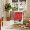 Red dots on a white background with black accents by Yayoi Kusama - in a Parisian living room with a sofa and a fig plant