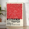 Red dots on a white background with black accents by Yayoi Kusama - in a bright minimalist room with a plant and an armchair