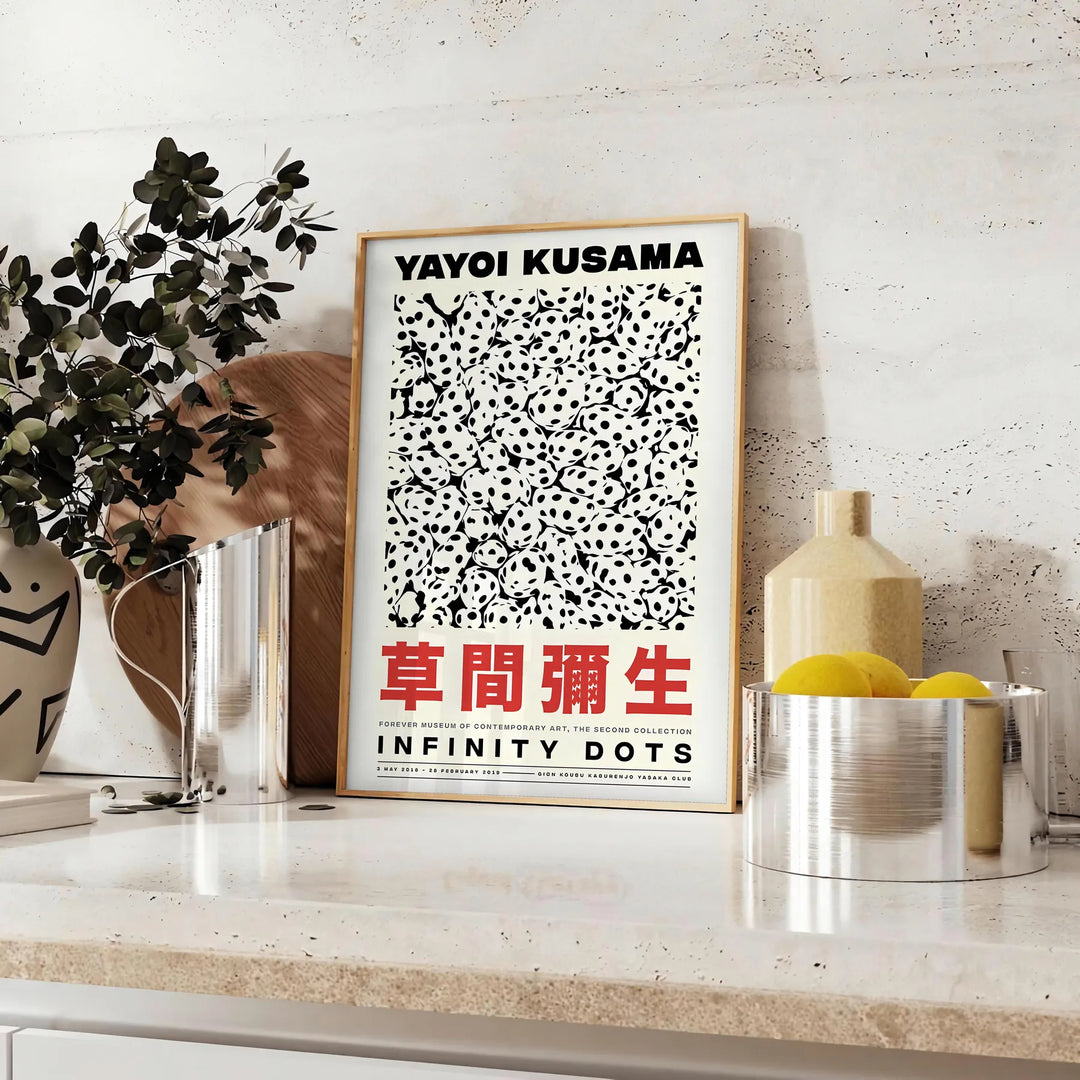Abstract polka dot patterns in orange and black by Yayoi Kusama - styled on a counter with eucalyptus and a bowl of lemons