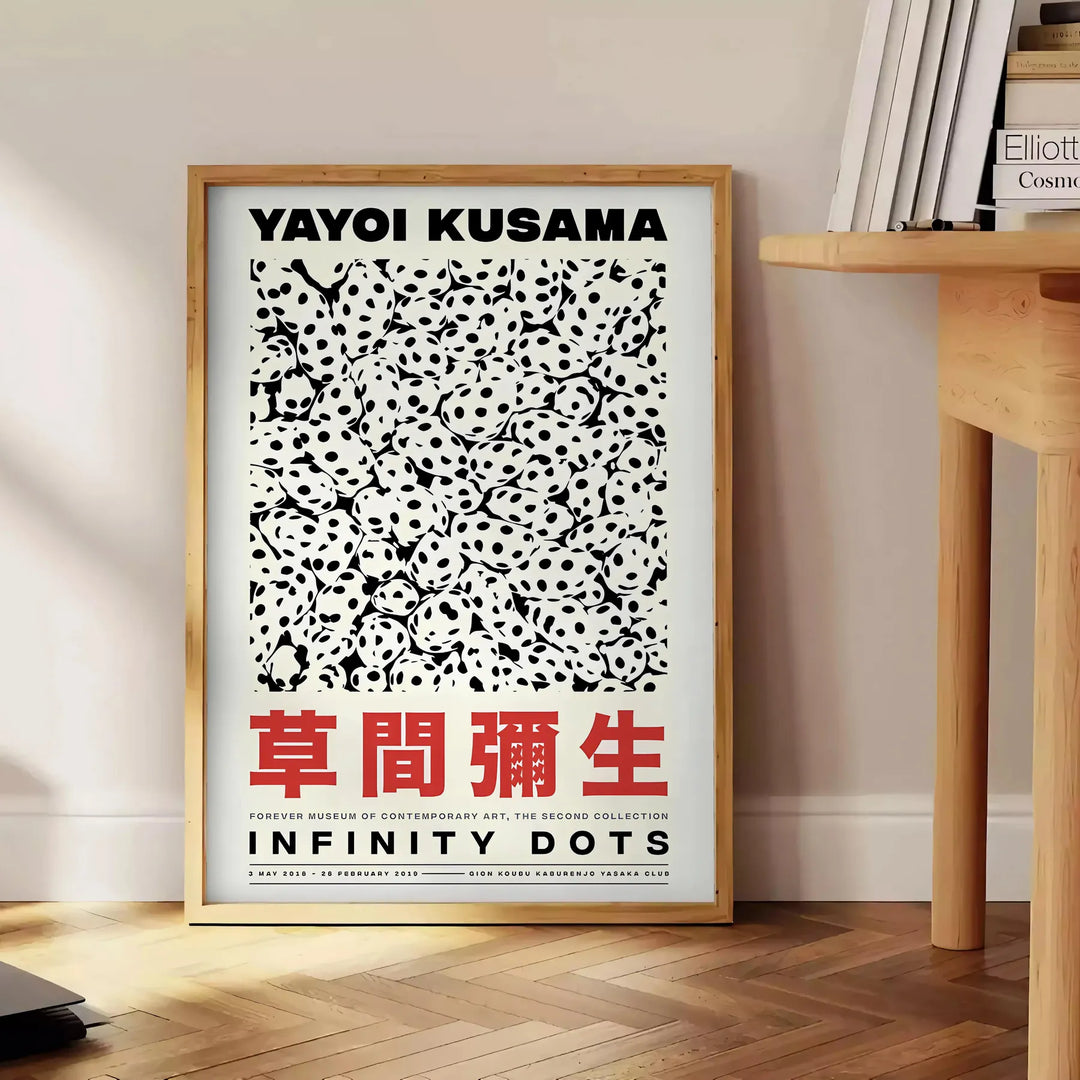 Abstract polka dot patterns in orange and black by Yayoi Kusama - beside a round wooden side table with books