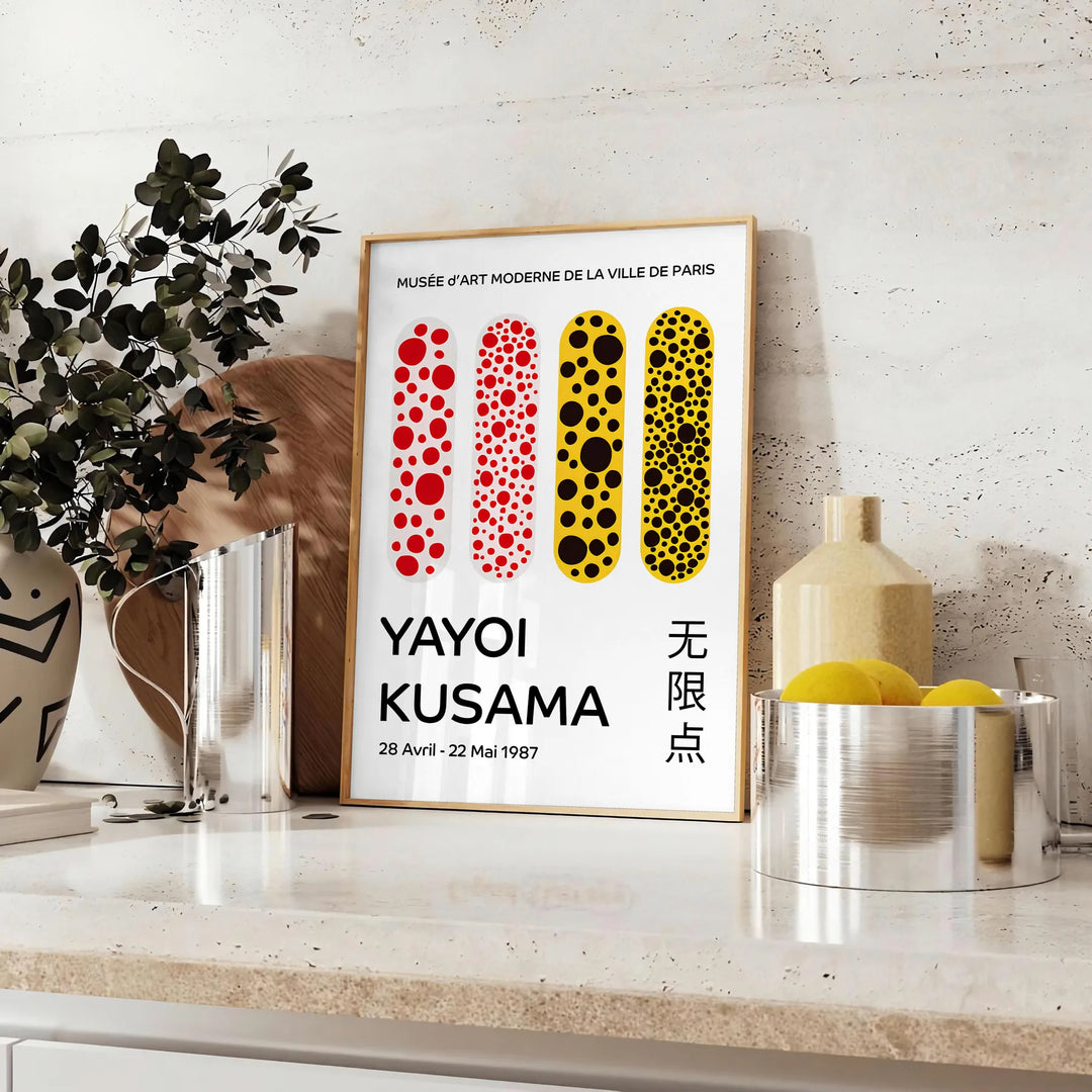 Abstrakte Punktmuster in Orange und Schwarz von Yayoi Kusama - auf einer Arbeitsplatte mit Eukalyptus und einer Schale Zitronen