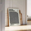 Black and white polka dot patterns with abstract shapes by Yayoi Kusama - leaning on a herringbone floor against a white panelled wall