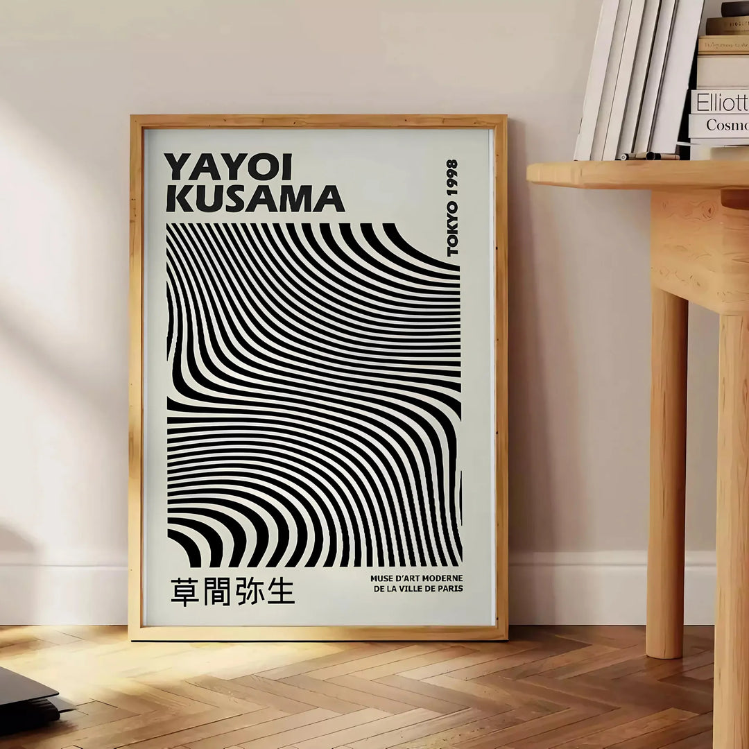 Black and white polka dot patterns with abstract shapes by Yayoi Kusama - beside a round wooden side table with books
