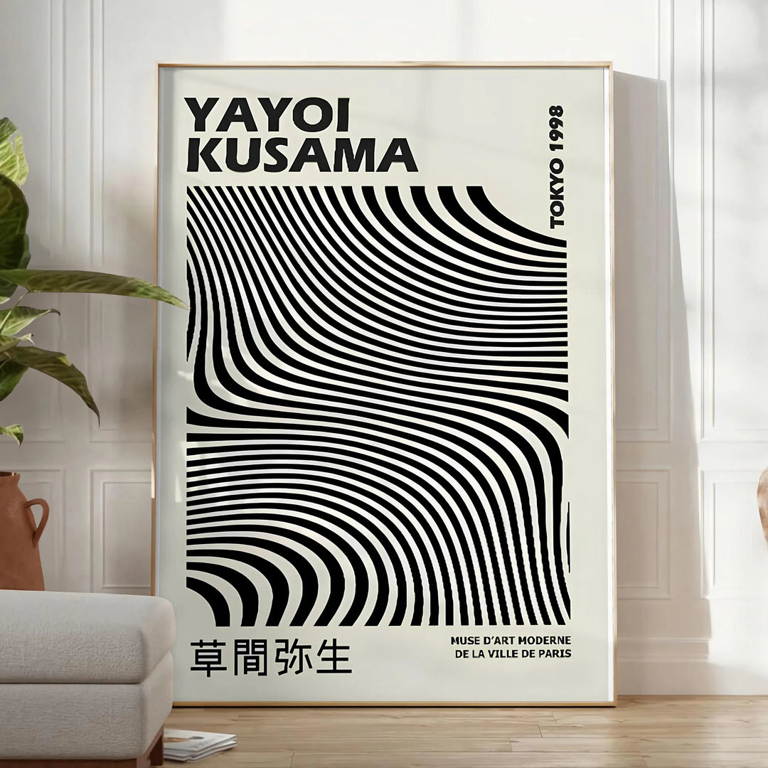 Black and white polka dot patterns with abstract shapes by Yayoi Kusama - in a bright minimalist room with a plant and an armchair