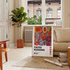 Colorful polka dots in green and orange by Yayoi Kusama - in a Parisian living room with a sofa and a fig plant