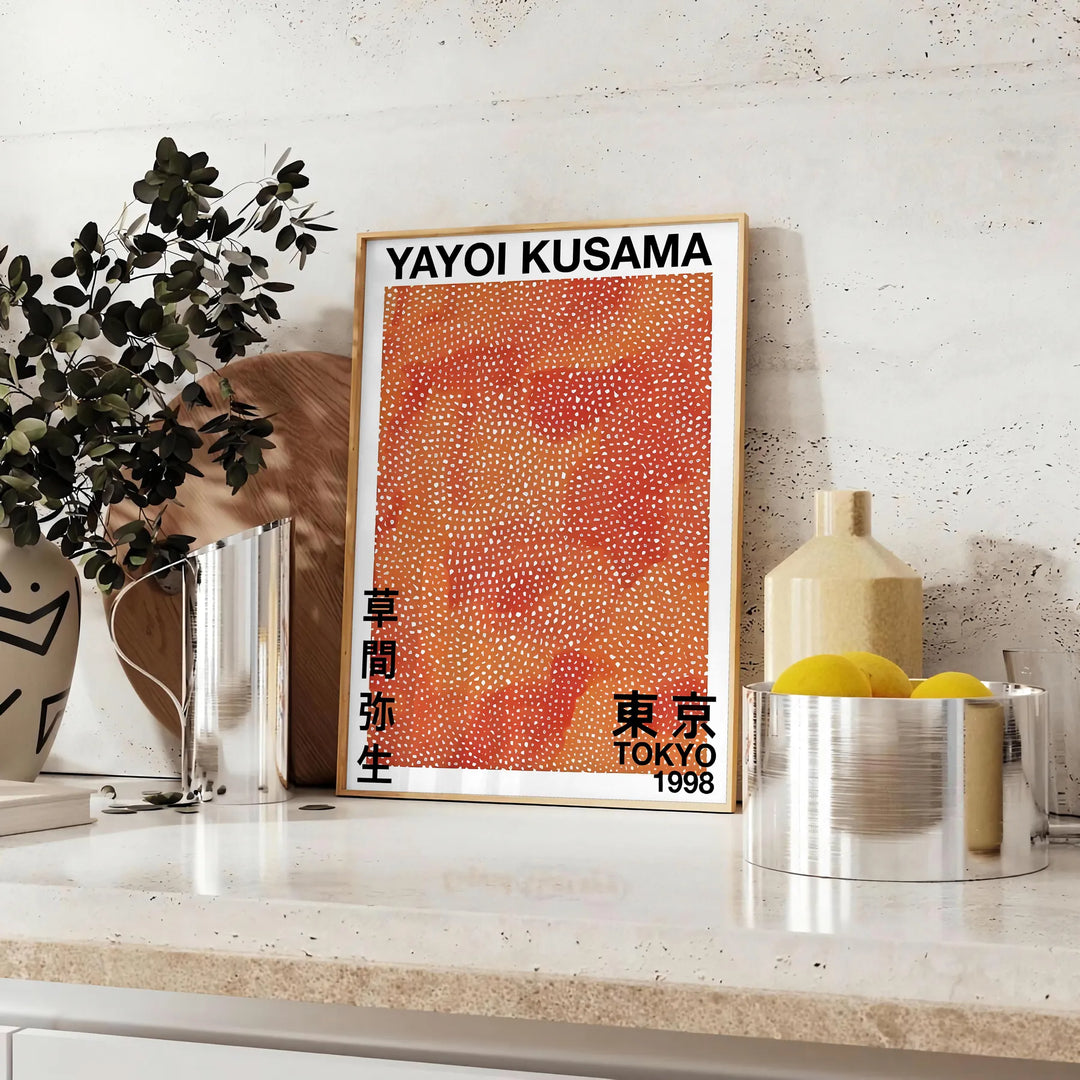 Motivi astratti a pois in nero e marrone di Yayoi Kusama - su un piano con eucalipto e una ciotola di limoni