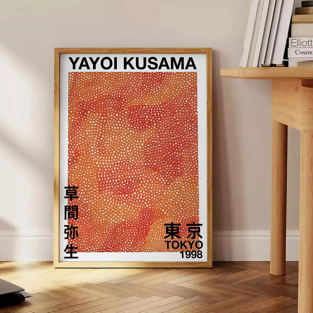 Motivi astratti a pois in nero e marrone di Yayoi Kusama - accanto a un tavolino rotondo in legno con libri