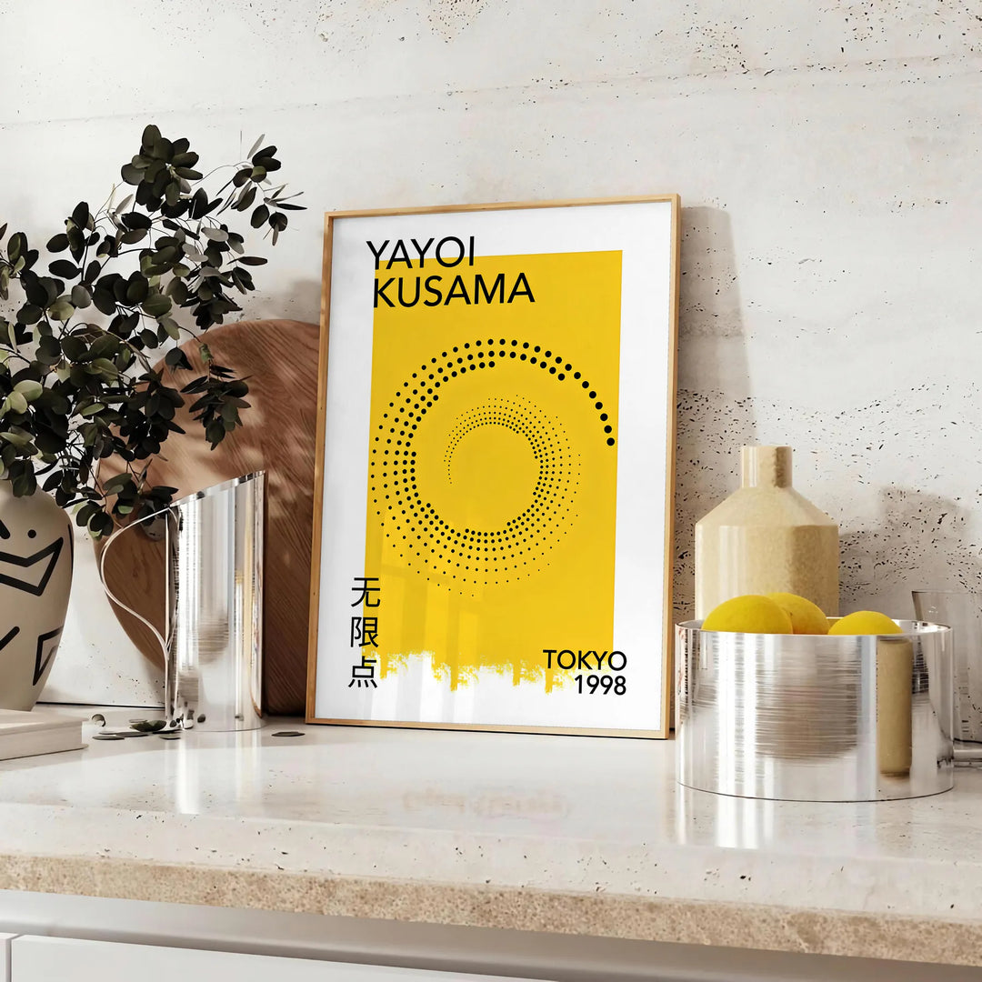 Abstract polka dot design in orange and black by Yayoi Kusama - styled on a counter with eucalyptus and a bowl of lemons