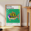 Colorful polka dots on a black background in Yayoi Kusama's signature style - beside a round wooden side table with books