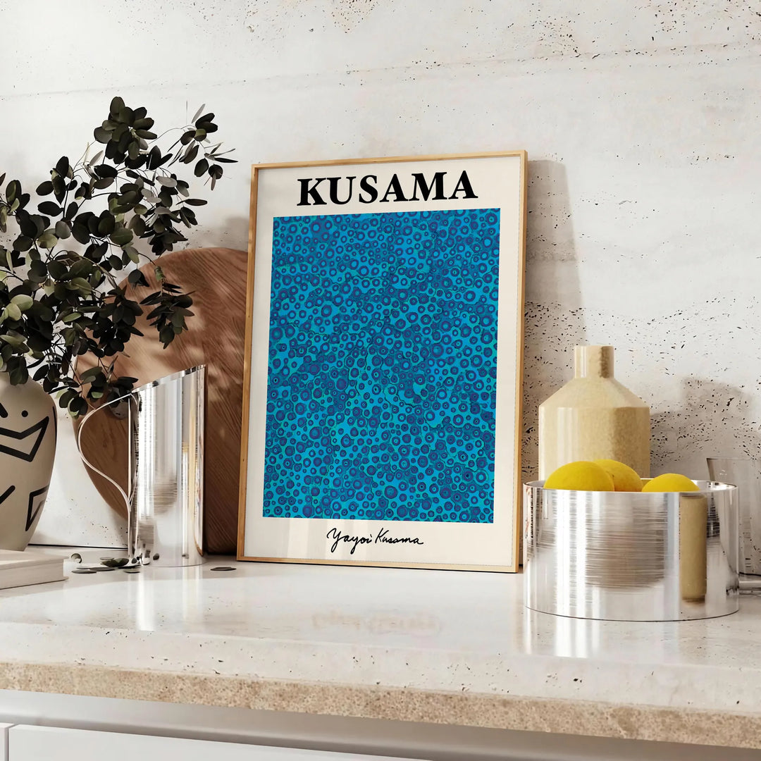 Abstract polka dot patterns in blue and black by Yayoi Kusama - styled on a counter with eucalyptus and a bowl of lemons