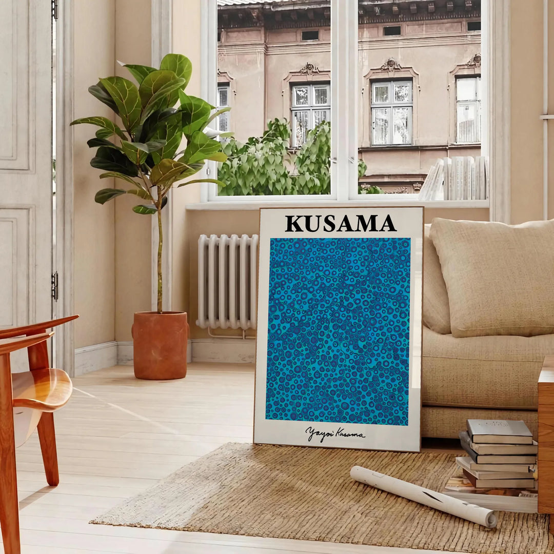 Abstract polka dot patterns in blue and black by Yayoi Kusama - in a Parisian living room with a sofa and a fig plant