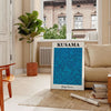 Abstract polka dot patterns in blue and black by Yayoi Kusama - in a Parisian living room with a sofa and a fig plant