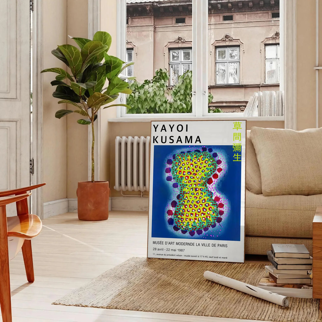 Colorful polka dots in various sizes on a deep blue background by Yayoi Kusama - in a Parisian living room with a sofa and a fig plant