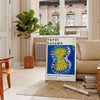 Colorful polka dots in various sizes on a deep blue background by Yayoi Kusama - in a Parisian living room with a sofa and a fig plant