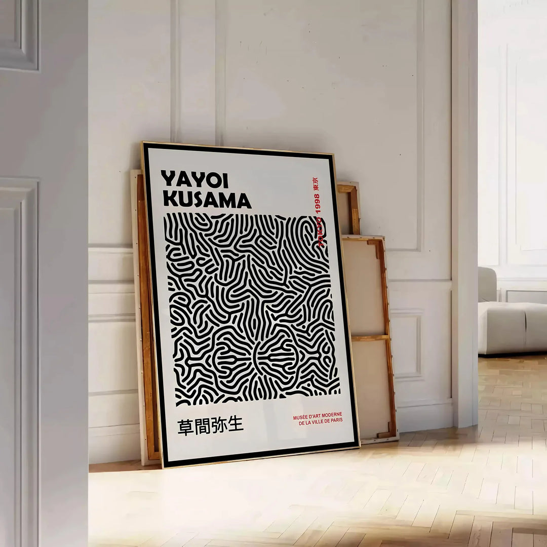 Abstract polka dot patterns in black and gray by Yayoi Kusama - leaning on a herringbone floor against a white panelled wall
