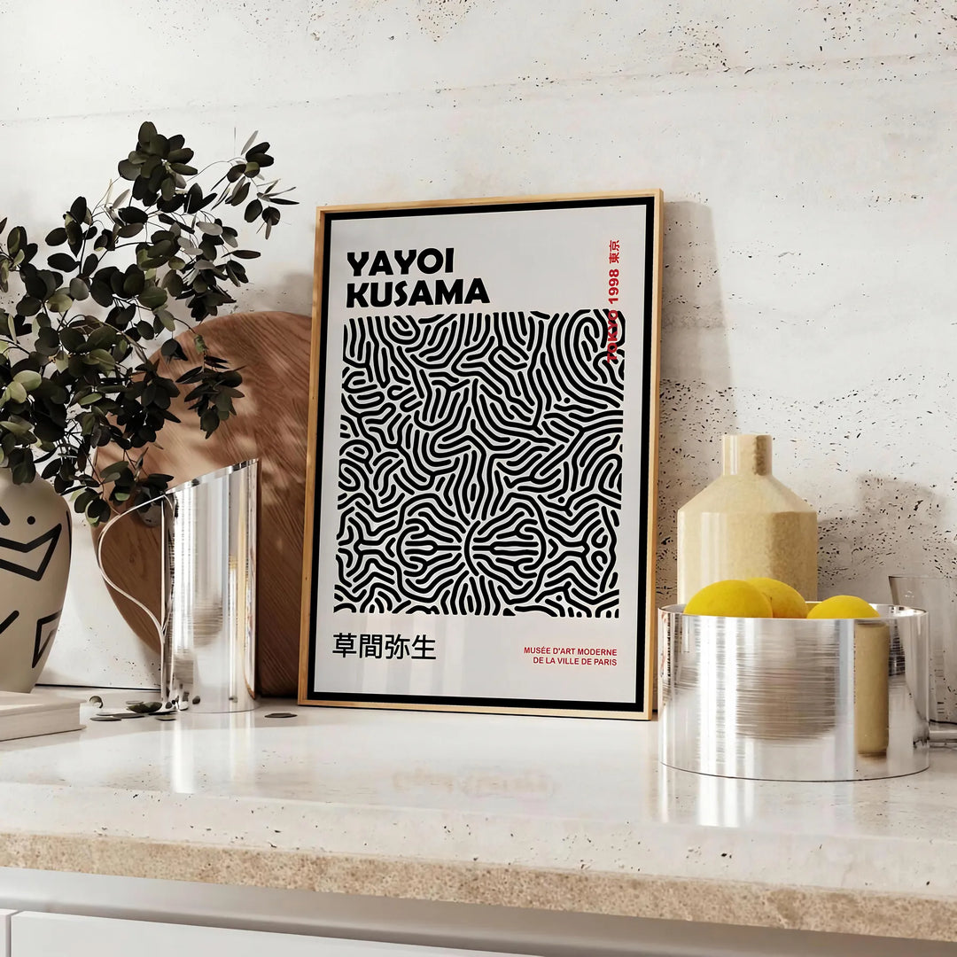 Abstract polka dot patterns in black and gray by Yayoi Kusama - styled on a counter with eucalyptus and a bowl of lemons