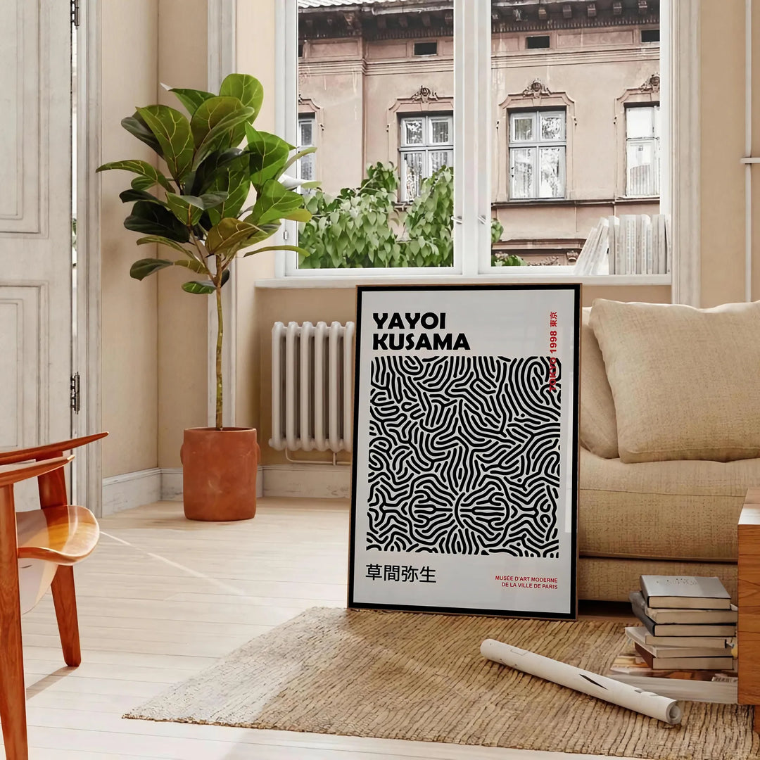 Abstract polka dot patterns in black and gray by Yayoi Kusama - in a Parisian living room with a sofa and a fig plant