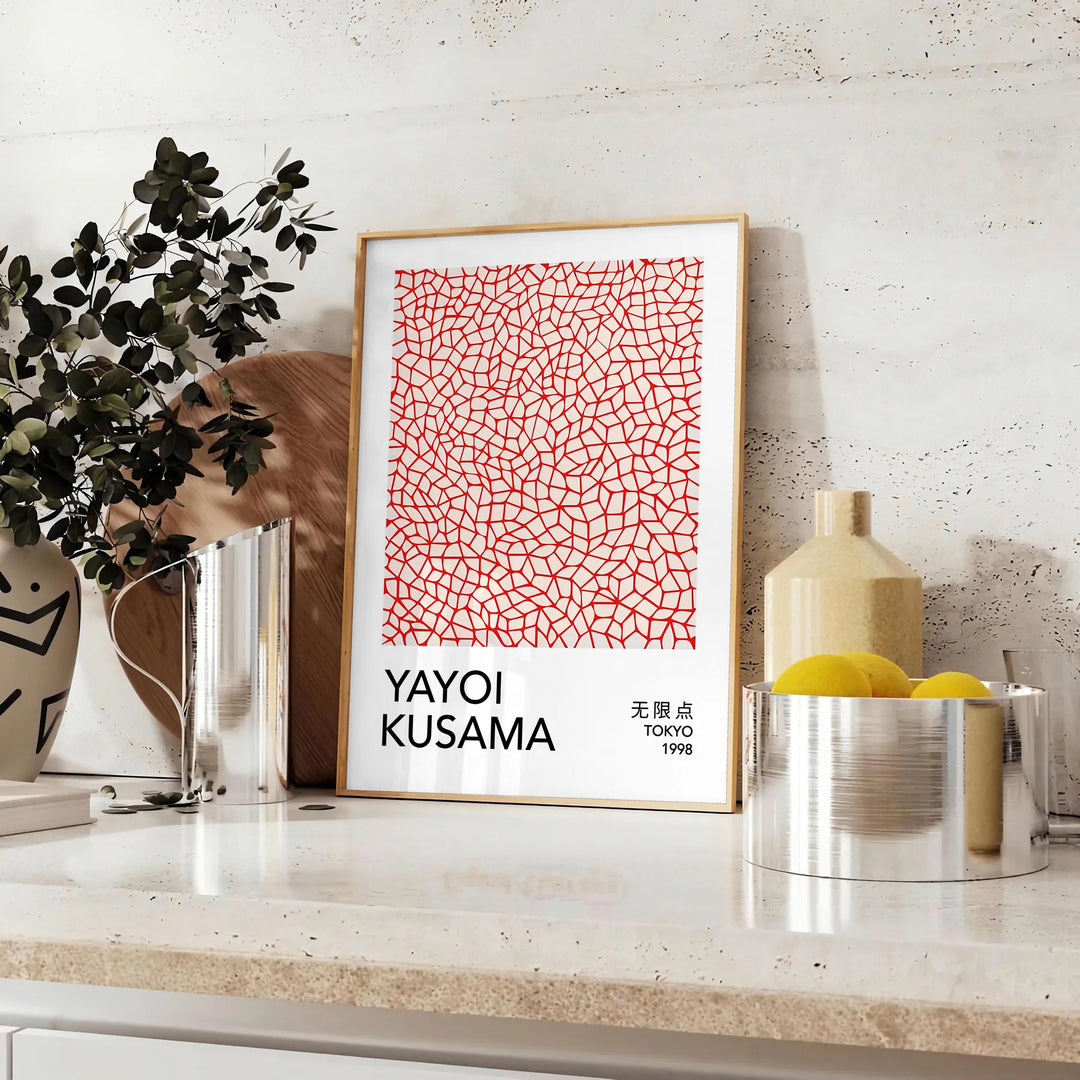 Motivi astratti di pois in arancione e nero di Yayoi Kusama - su un piano con eucalipto e una ciotola di limoni