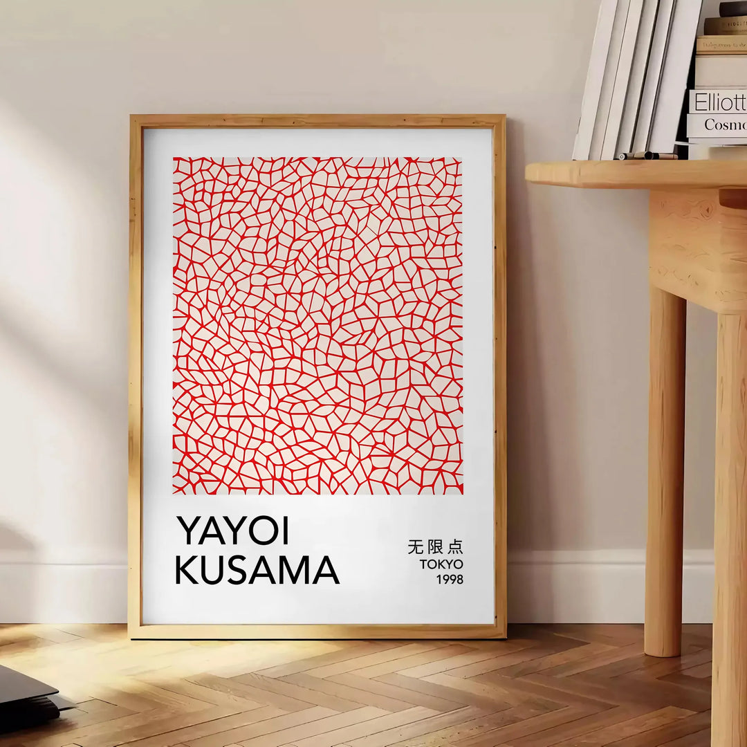 Motivi astratti di pois in arancione e nero di Yayoi Kusama - accanto a un tavolino rotondo in legno con libri